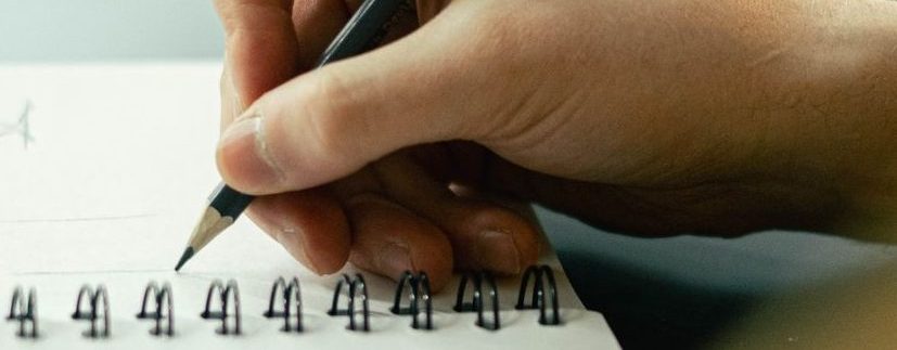 person drawing on a sketchbook
